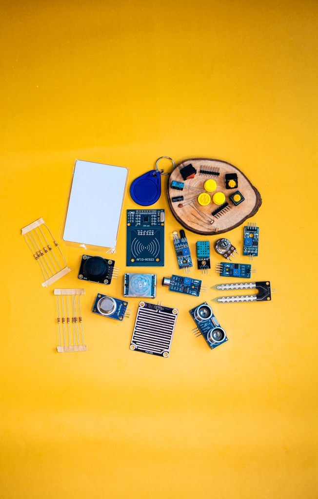 A collection of electronic components arranged on a vibrant yellow surface, ideal for tech enthusiasts.