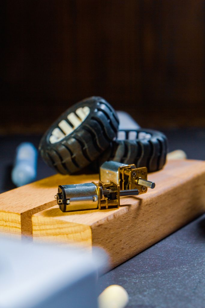 Detailed close-up of robot wheel components and motors on a wooden base, ideal for tech projects.